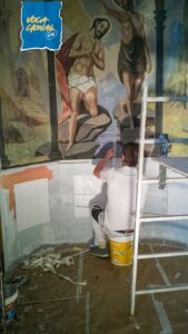 homem restaurando uma pintura do profeta João b Batista